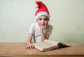 ÃÂ¡ute girl in Santa Claus hat eat cookies.